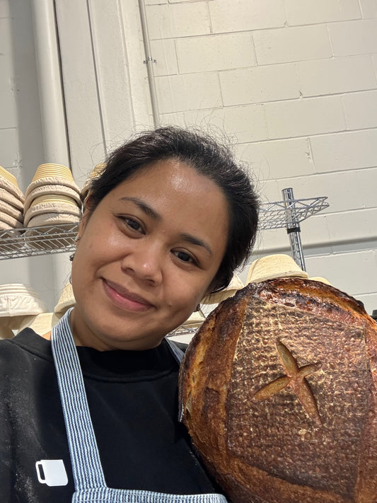 Person holding a large loaf of Sourdough Bread